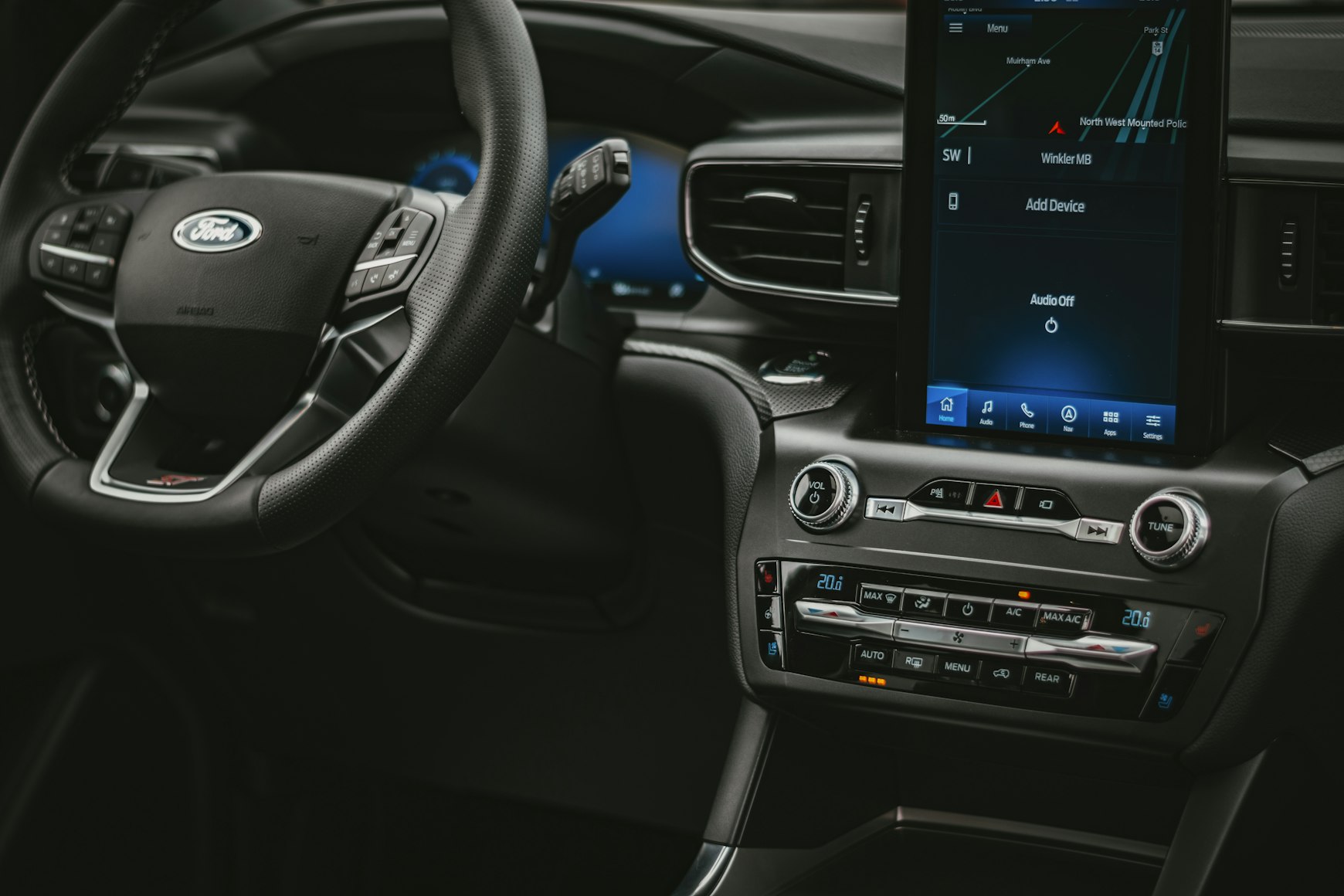 Interior of a Ford model with a view of a dashboard screen and steering wheel.