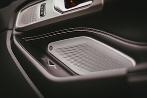Side view of a luxury car door panel reupholstered in rich leather, highlighting smooth curves and fine craftsmanship.
