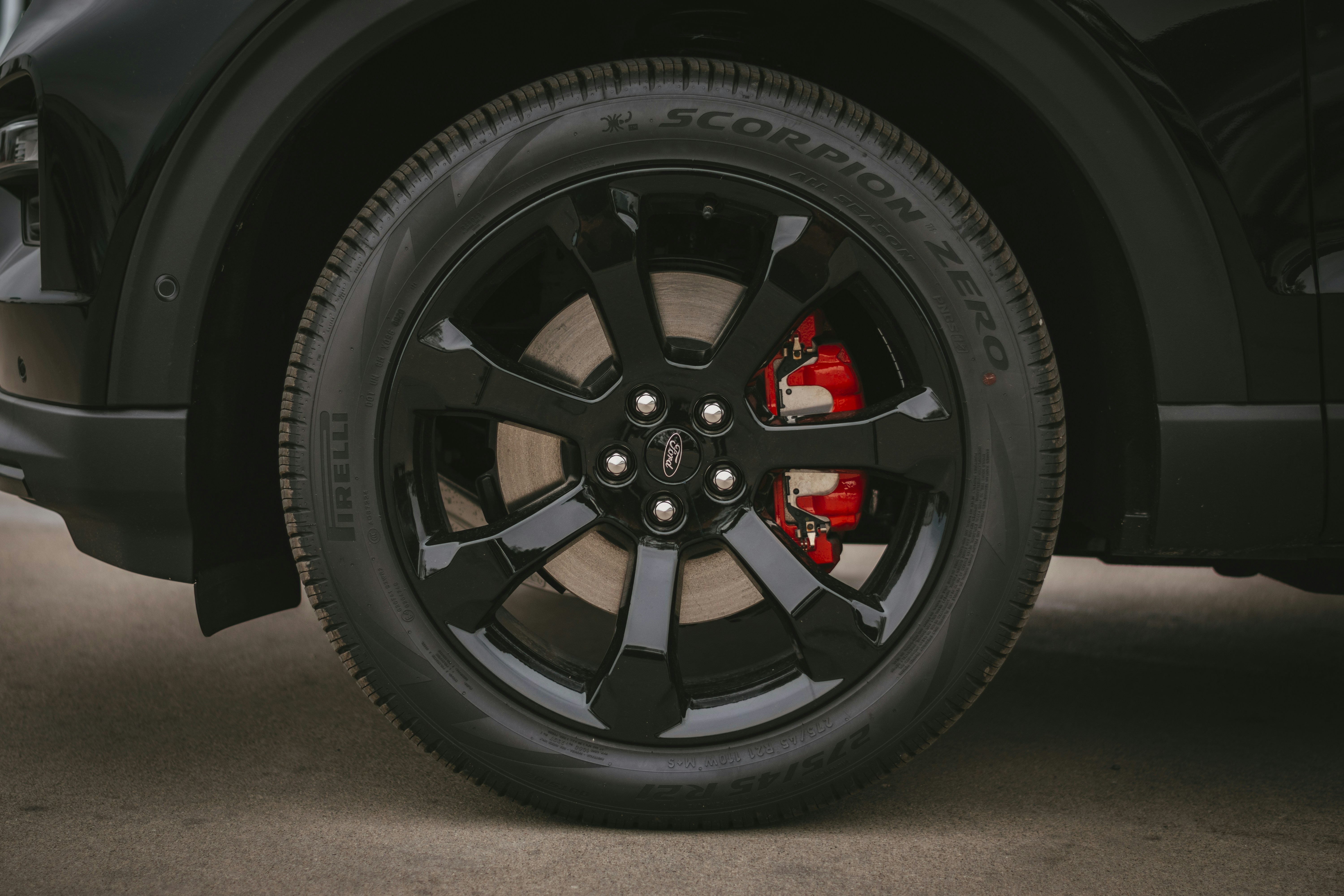 Row of used Tesla Model 3 sedans lined up at a dealership lot
