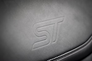 A close-up of a leather menu cover with embossed logo.
