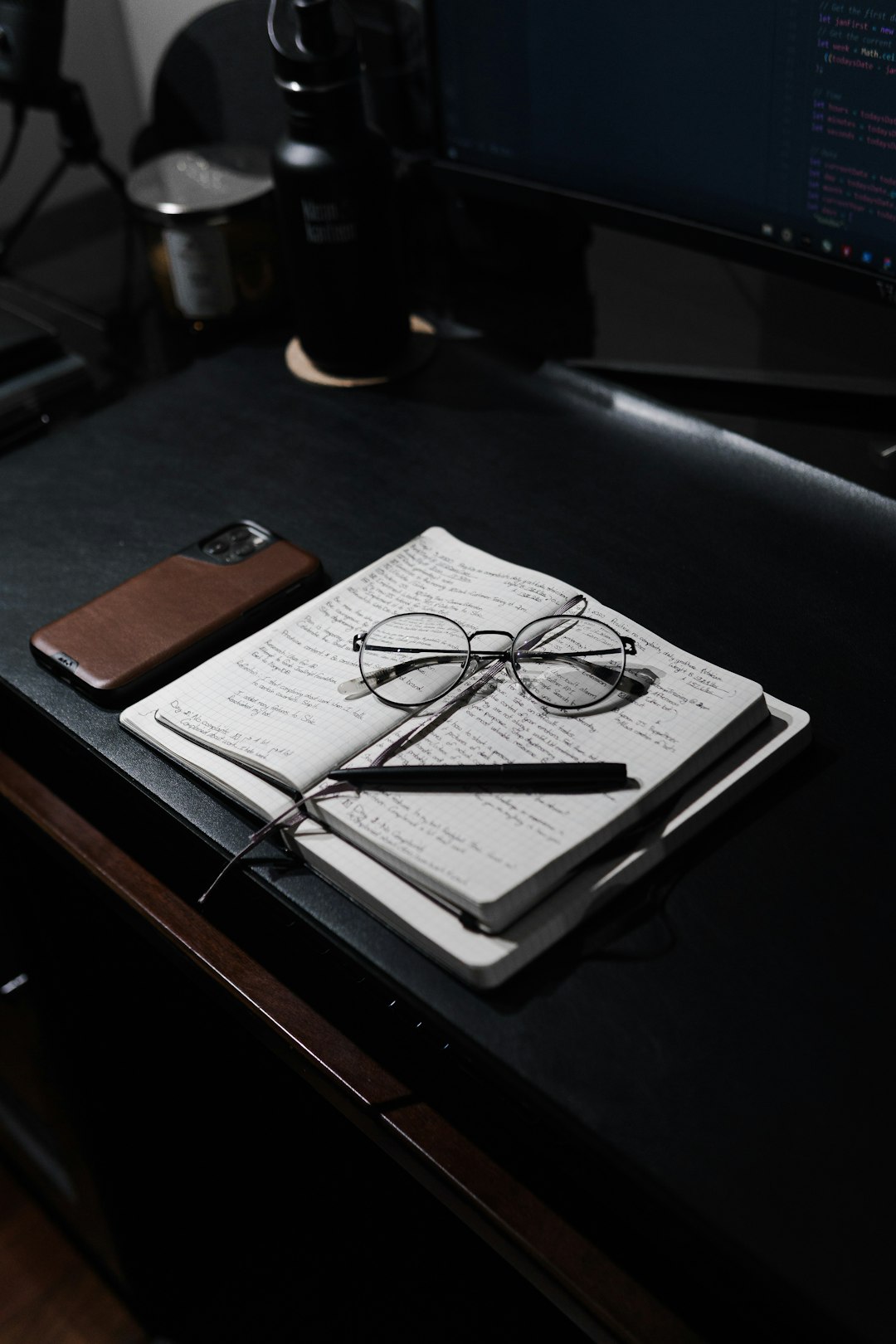 black framed eyeglasses on white printer paper