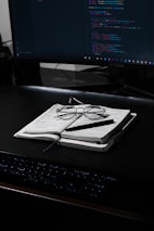 black framed eyeglasses on white paper