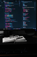 A tidy workspace with a notebook, coffee cup, and a glowing monitor displaying a portfolio site.