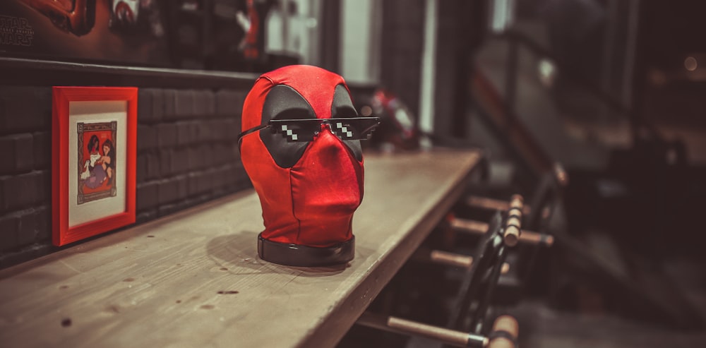 máscara vermelha e preta na mesa de madeira marrom