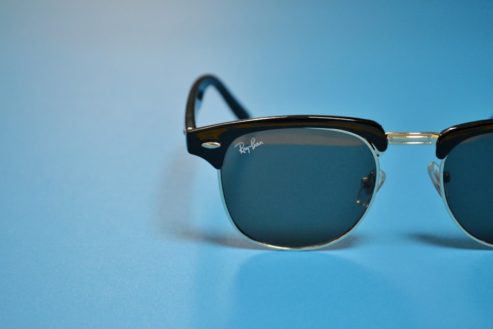 black framed sunglasses on white surface