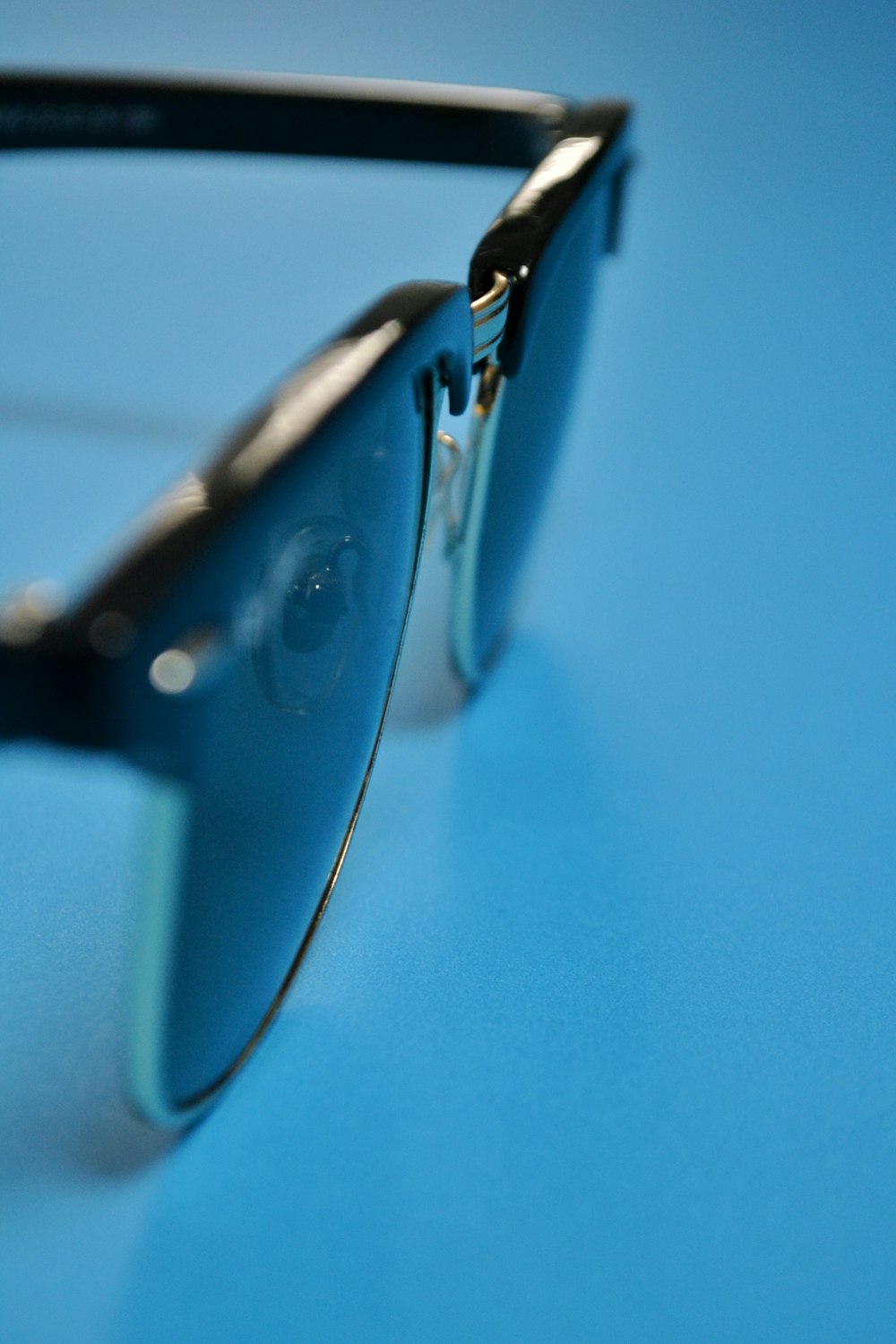 black framed sunglasses on blue surface