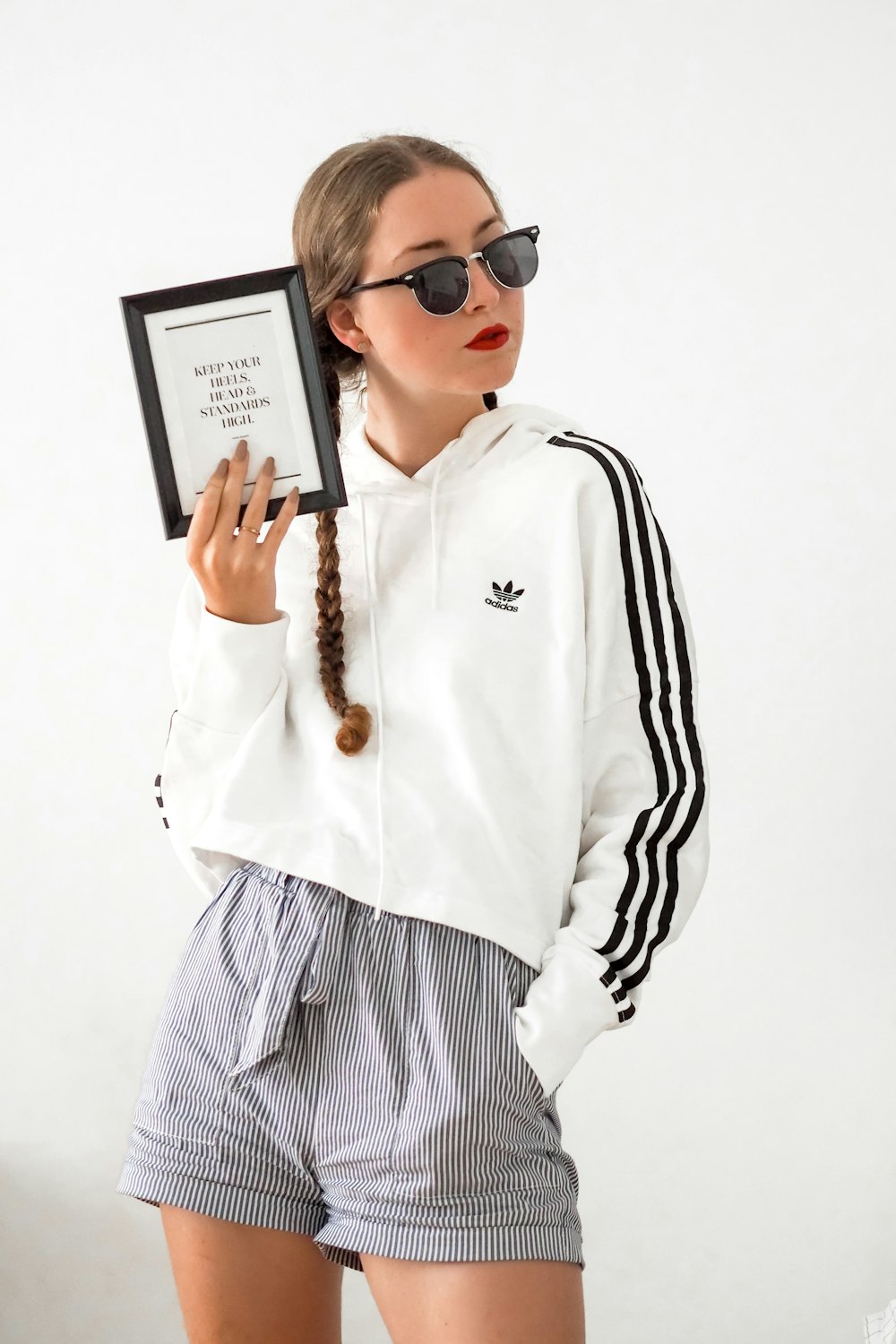 man in white and black adidas long sleeve shirt holding black tablet computer