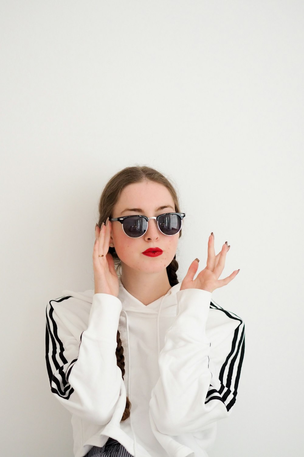 woman in white dress shirt wearing black framed sunglasses