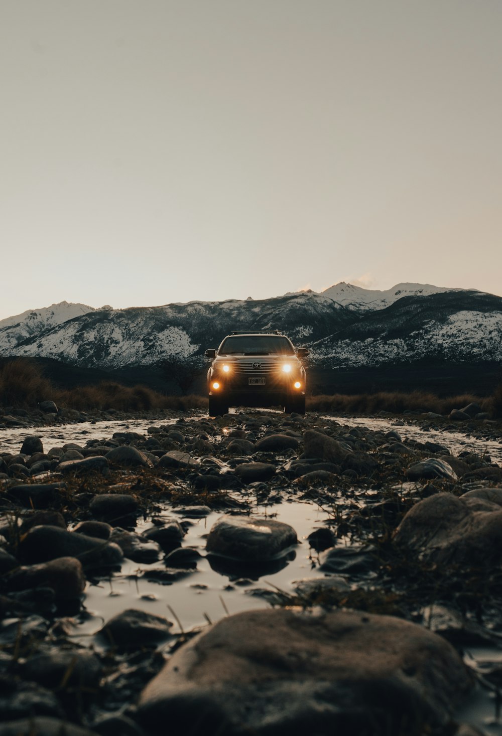 white car on rocky field during daytime