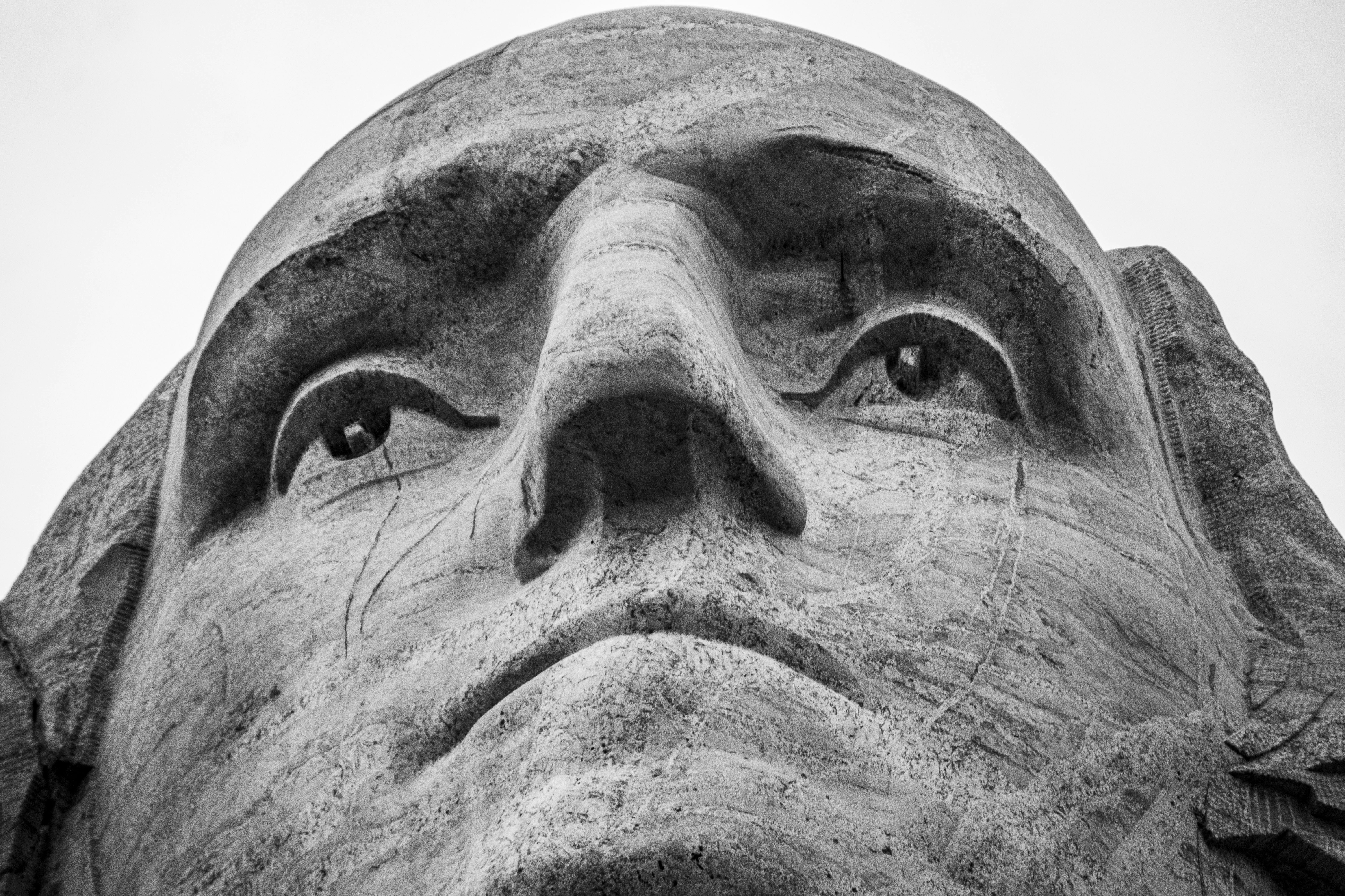 gray scale photo of mans face head teams background