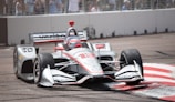 white and red f 1 car on road