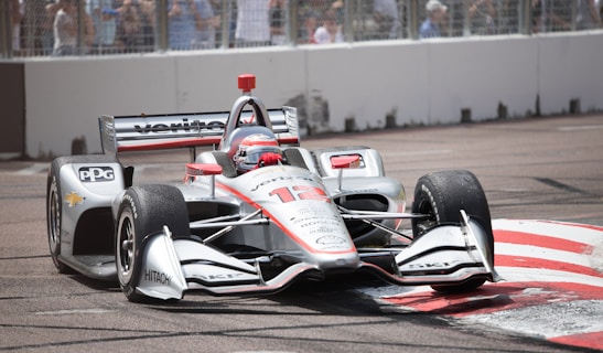 white and red f 1 car on road