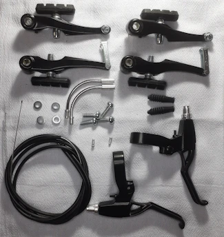 Close-up of premium brake pads and engine parts arranged neatly on a dark surface.