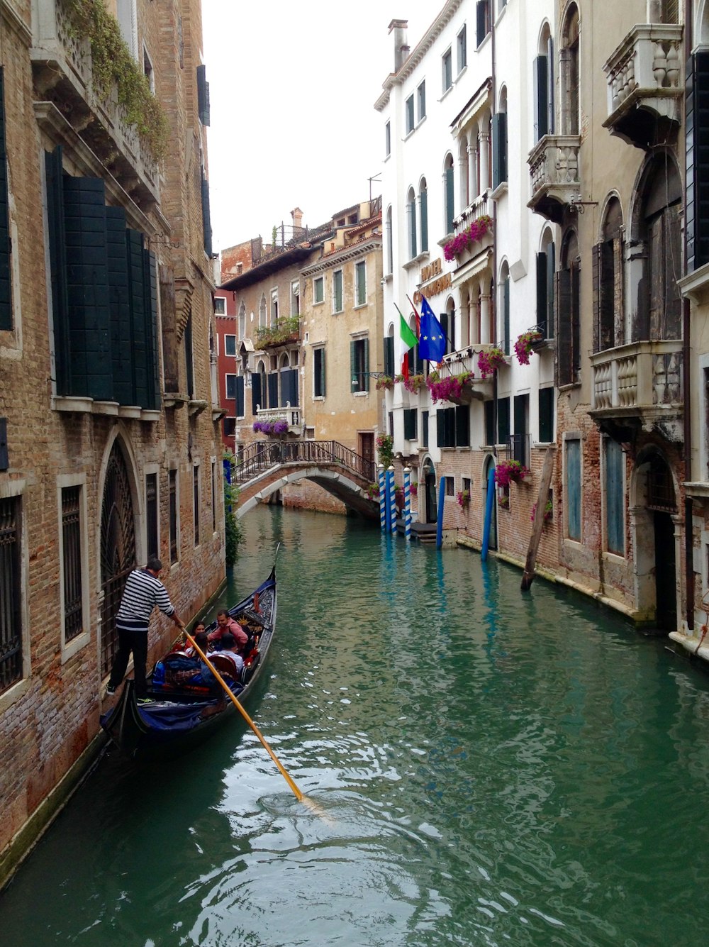 boat on river between buildings during daytime