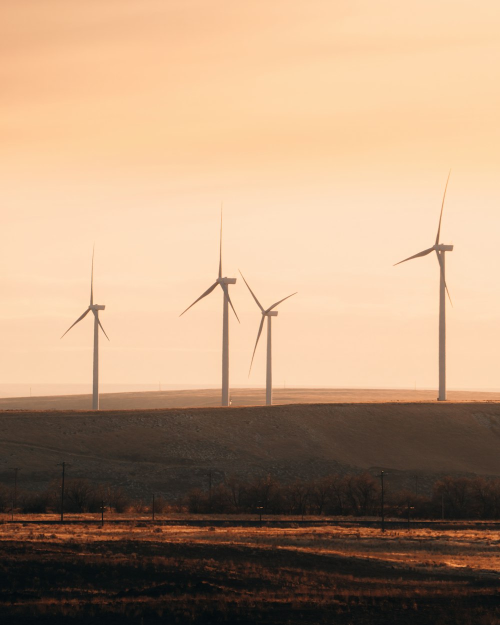 wind turbines on brown field during daytime