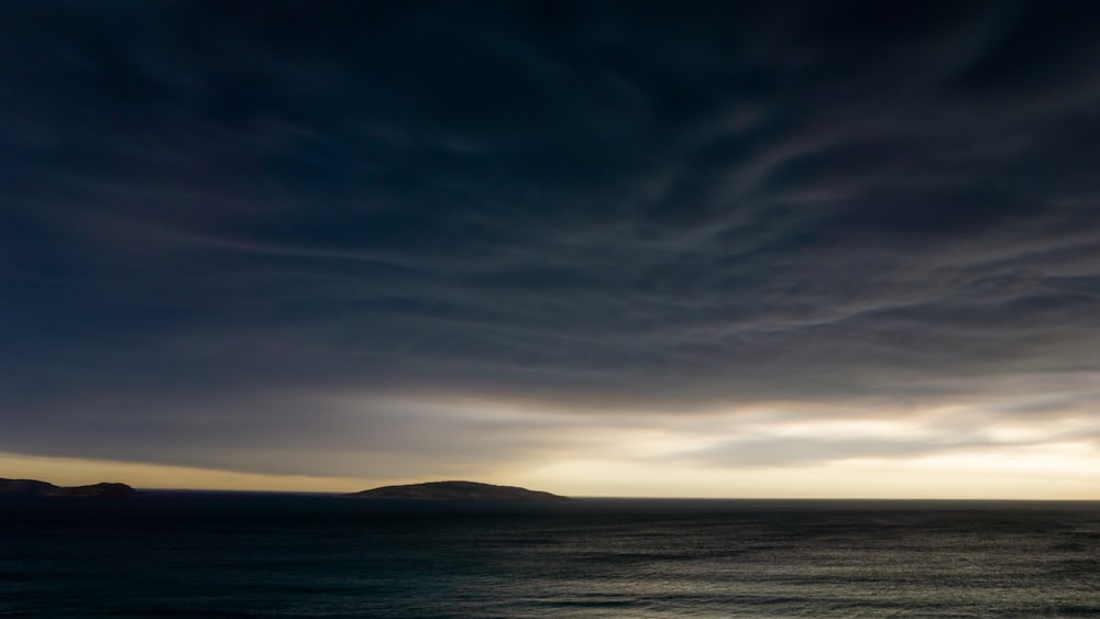 body of water under cloudy sky during daytime