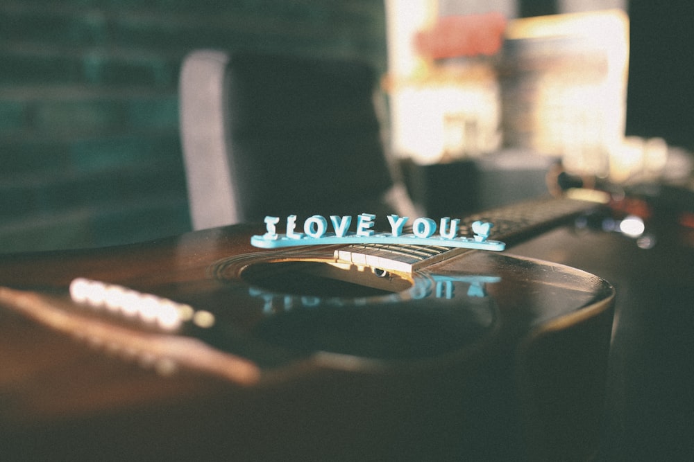 a close up of a guitar with the words i love you on it