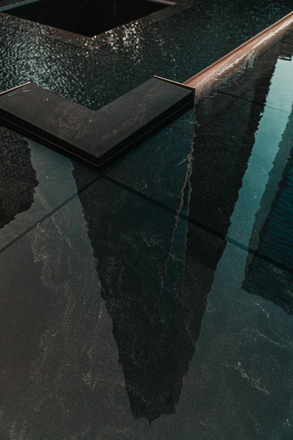 Sol en béton noir près de la piscine