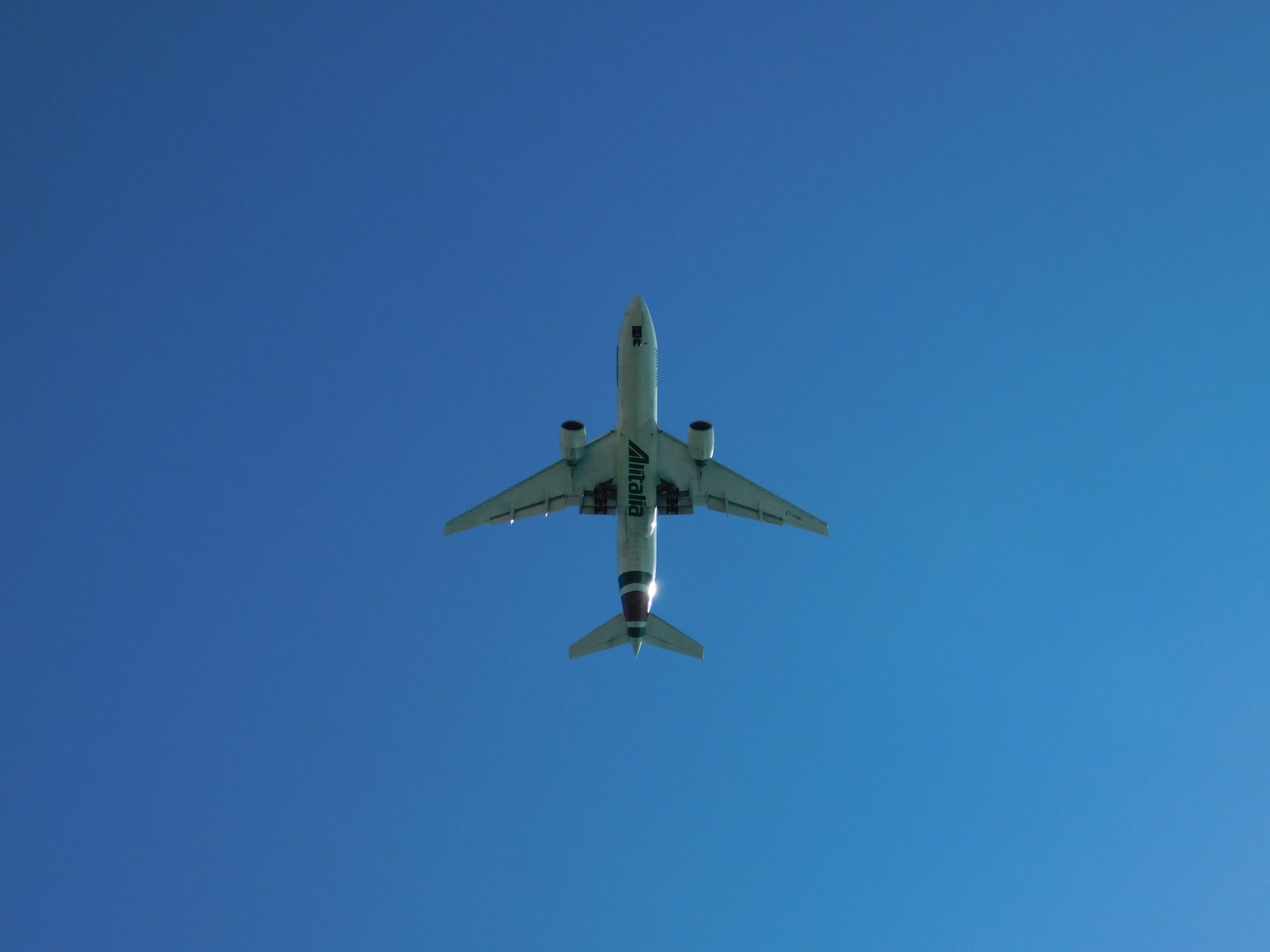 white airplane in mid air during daytime