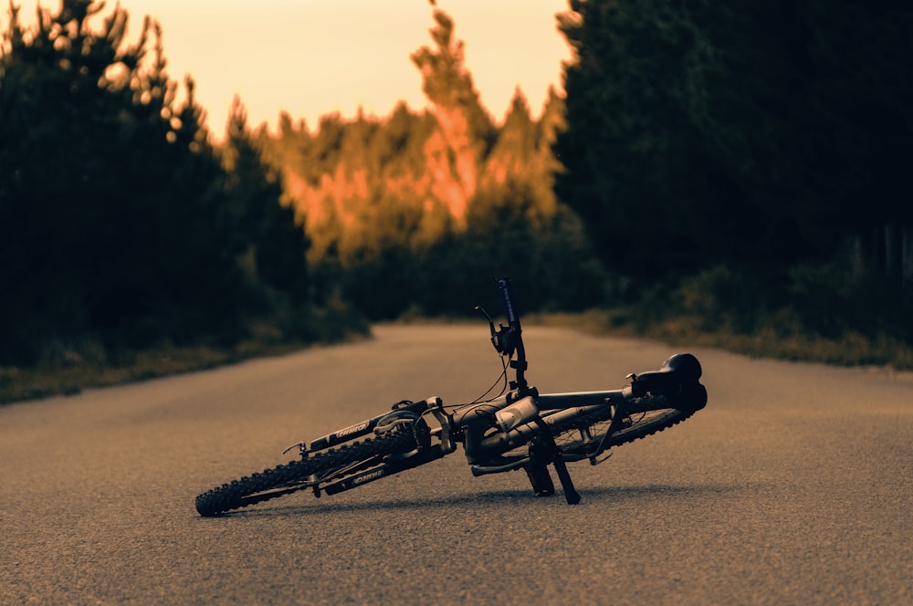 a bike laying on its side on the side of the road