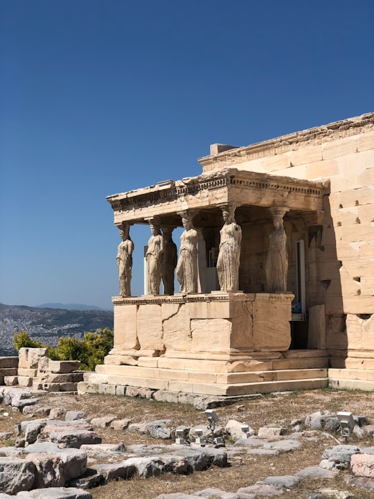 beige concrete building under blue sky during daytime in Acropolis of Athens Greece