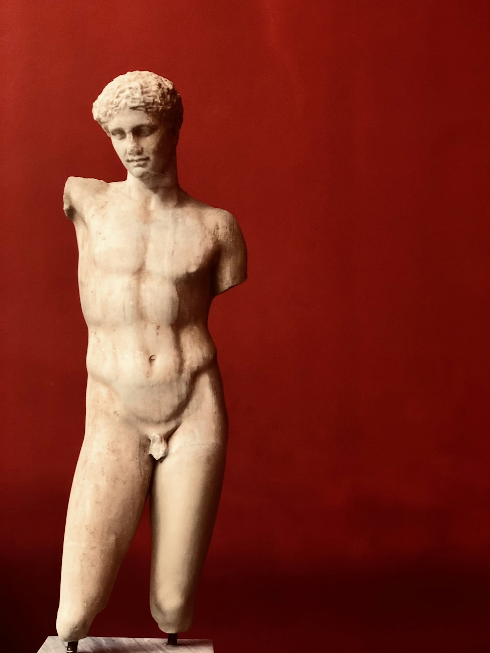 Estátua da mulher de topless no fundo vermelho