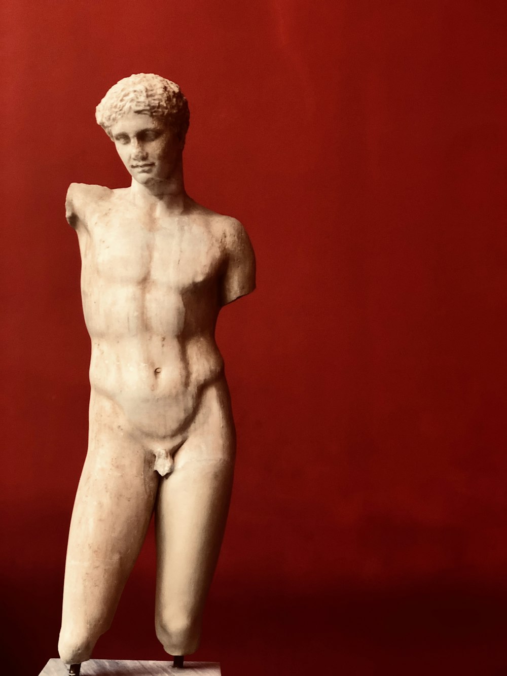topless woman statue on red background