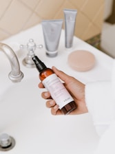 person holding white labeled bottle