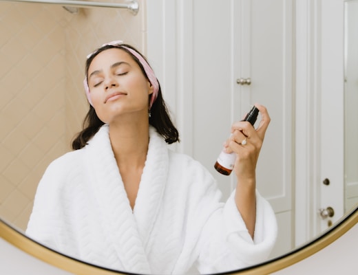 woman in white bathrobe holding smartphone