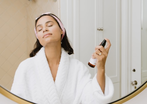 woman in white bathrobe holding smartphone