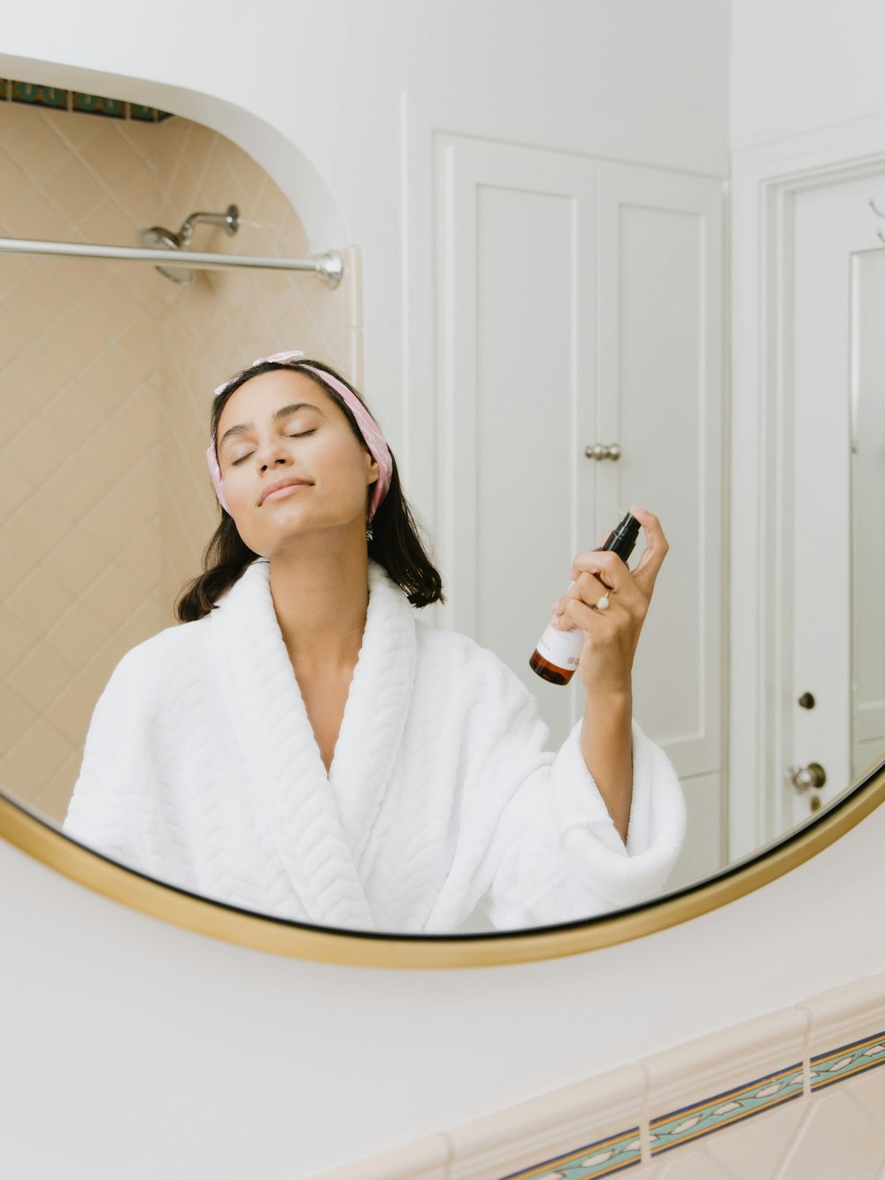 woman in white bathrobe holding smartphone