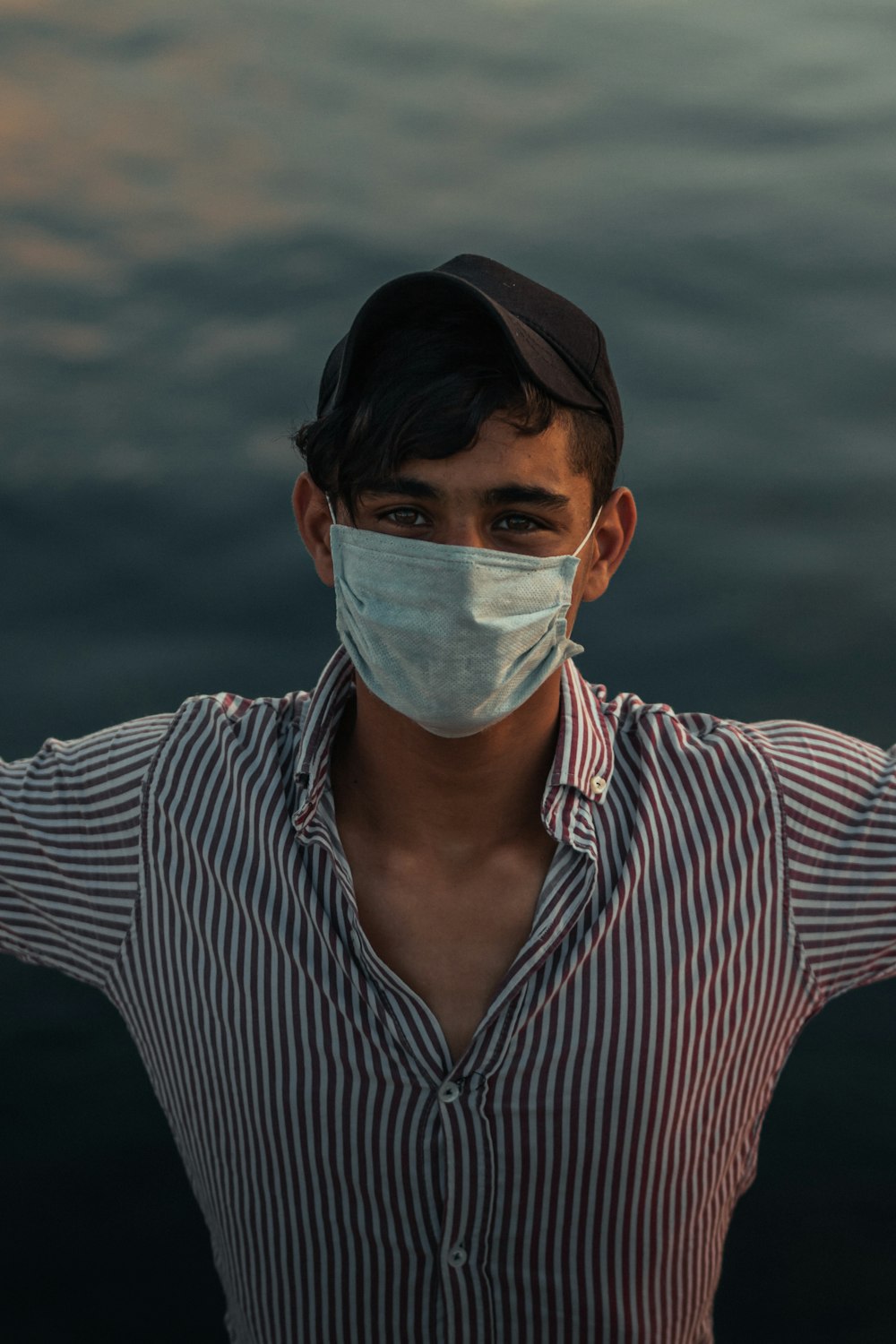 man in black and white striped dress shirt with white face mask