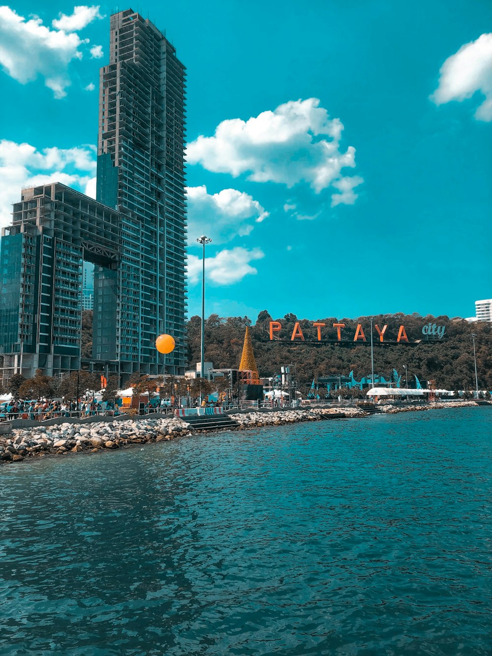 white boat on sea near city buildings under blue and white sunny cloudy sky during daytime