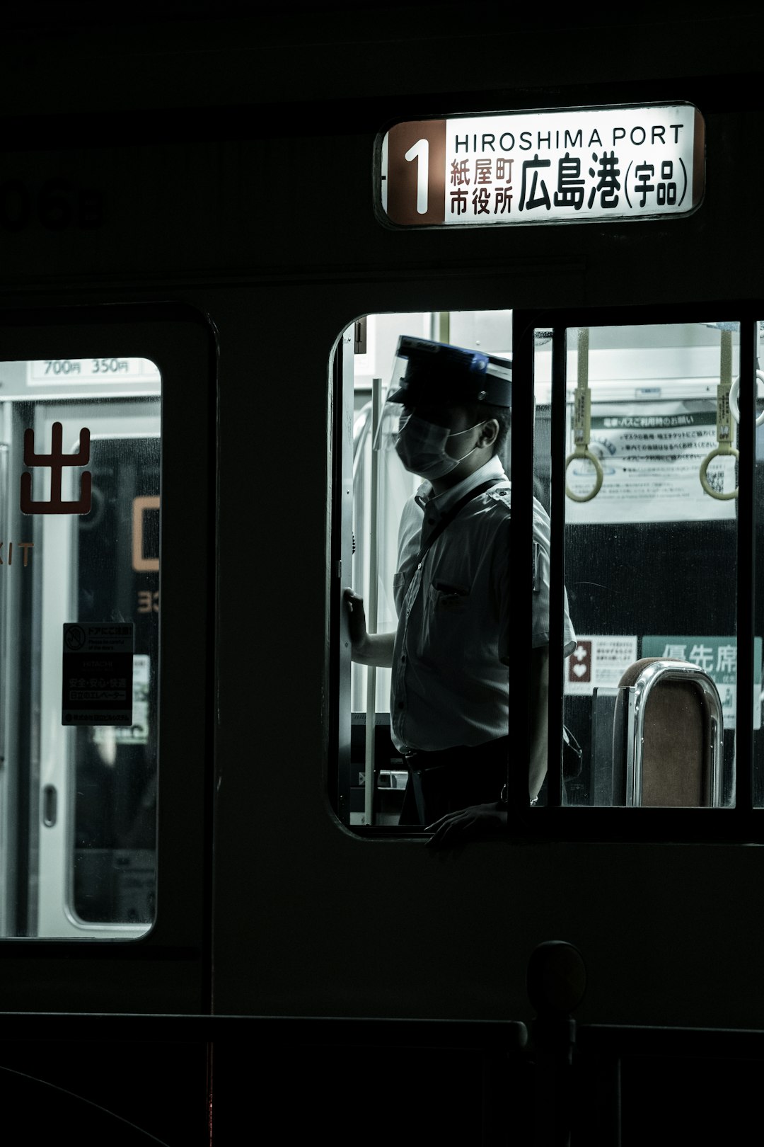 man in black jacket standing in train