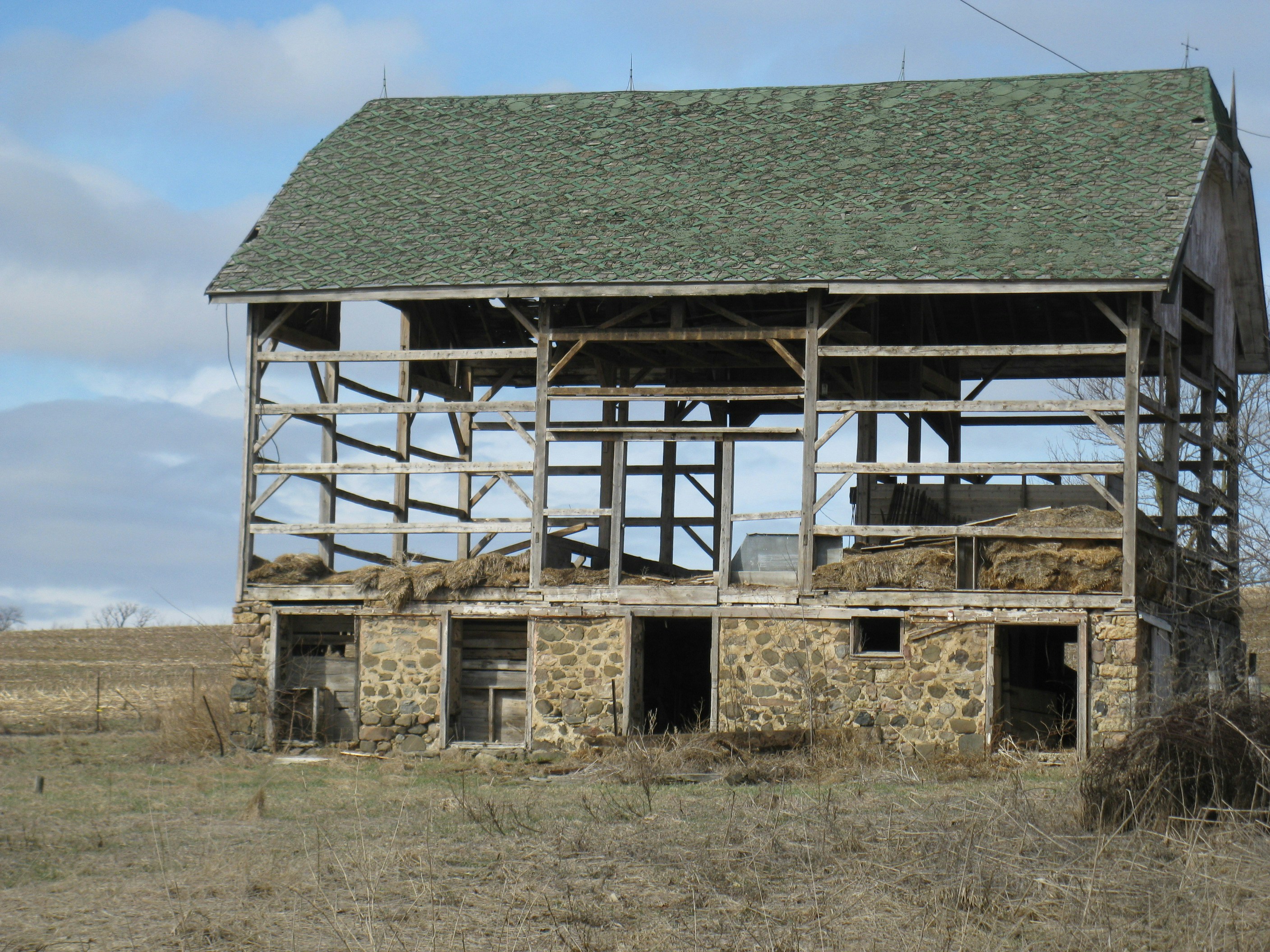 gray wooden house on brown field under blue sky during daytime