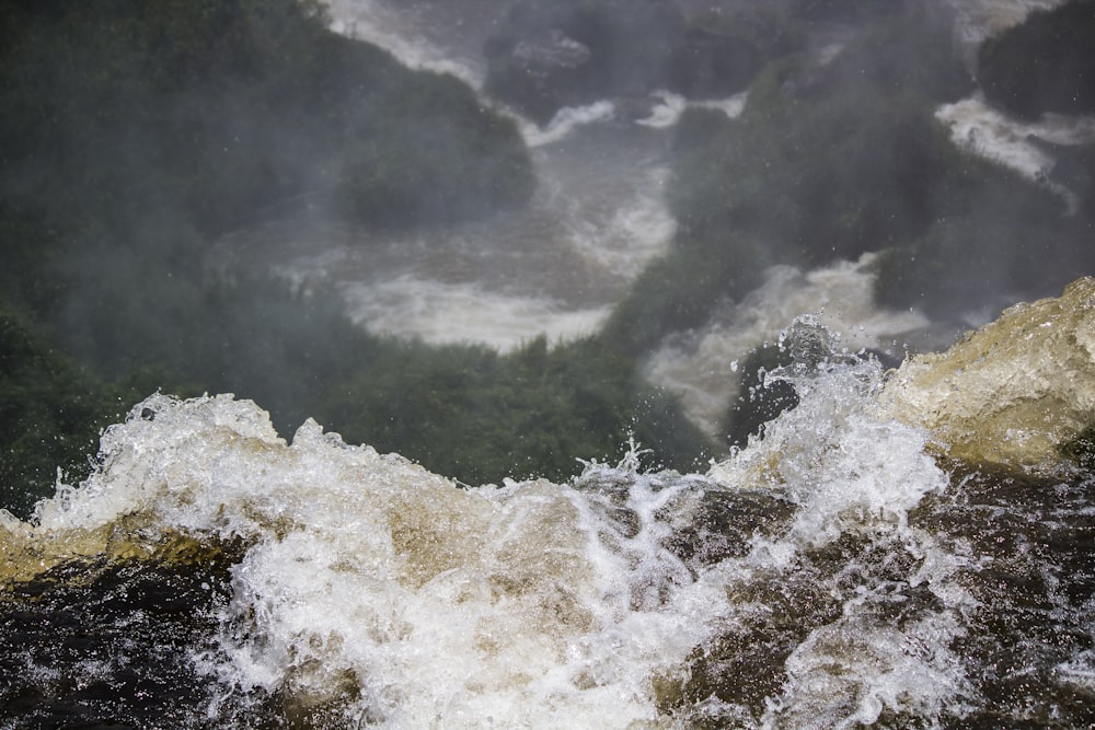 water waves hitting rocks during daytime