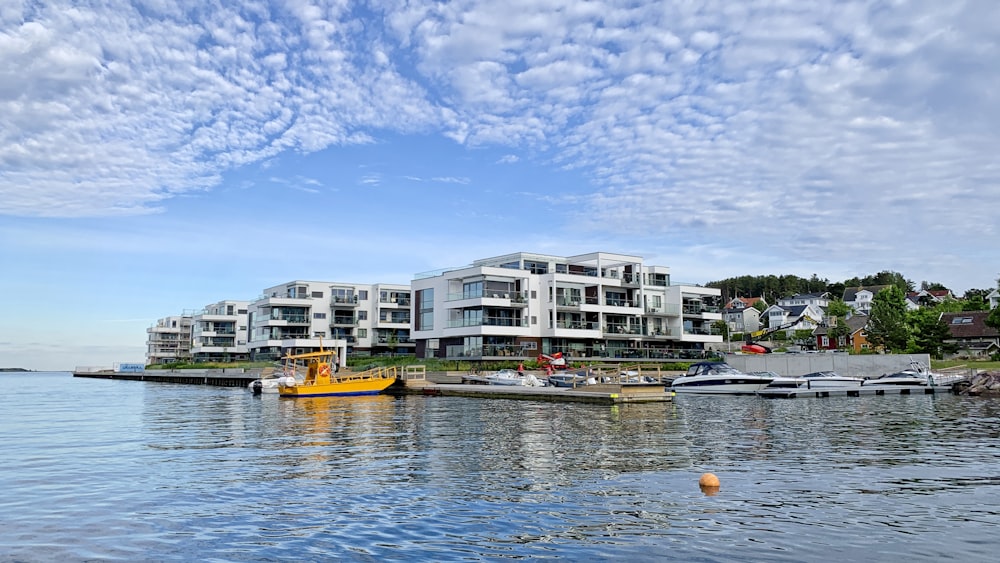 white and brown concrete building beside body of water under blue sky during daytime