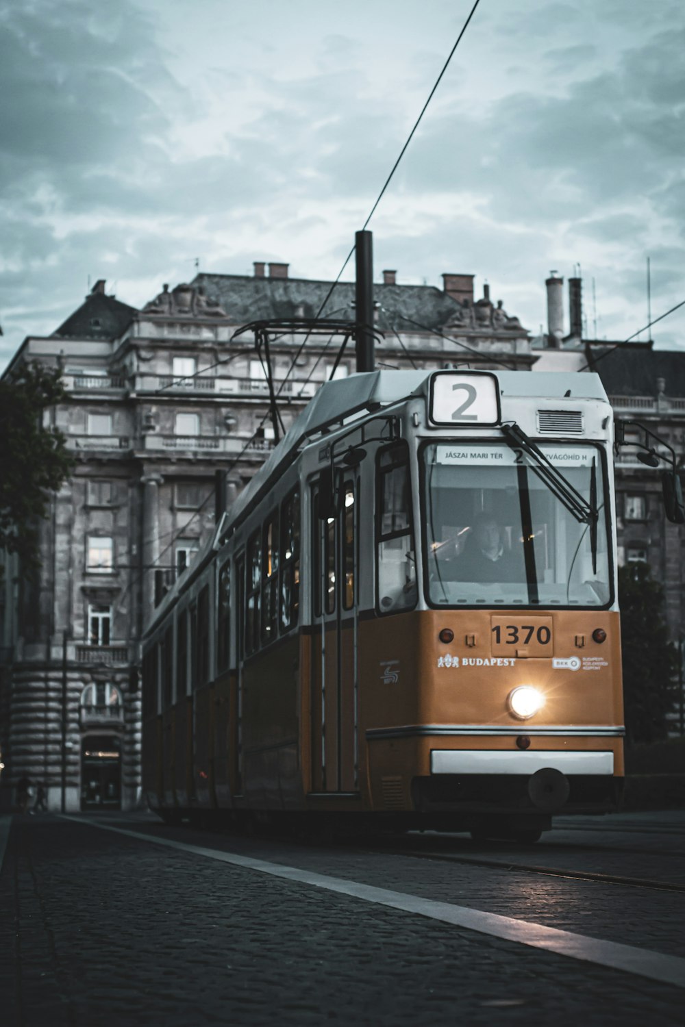 yellow and white tram on road near building during daytime