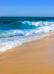 sea waves crashing on shore during daytime
