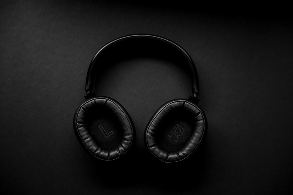 black and silver headphones on black surface