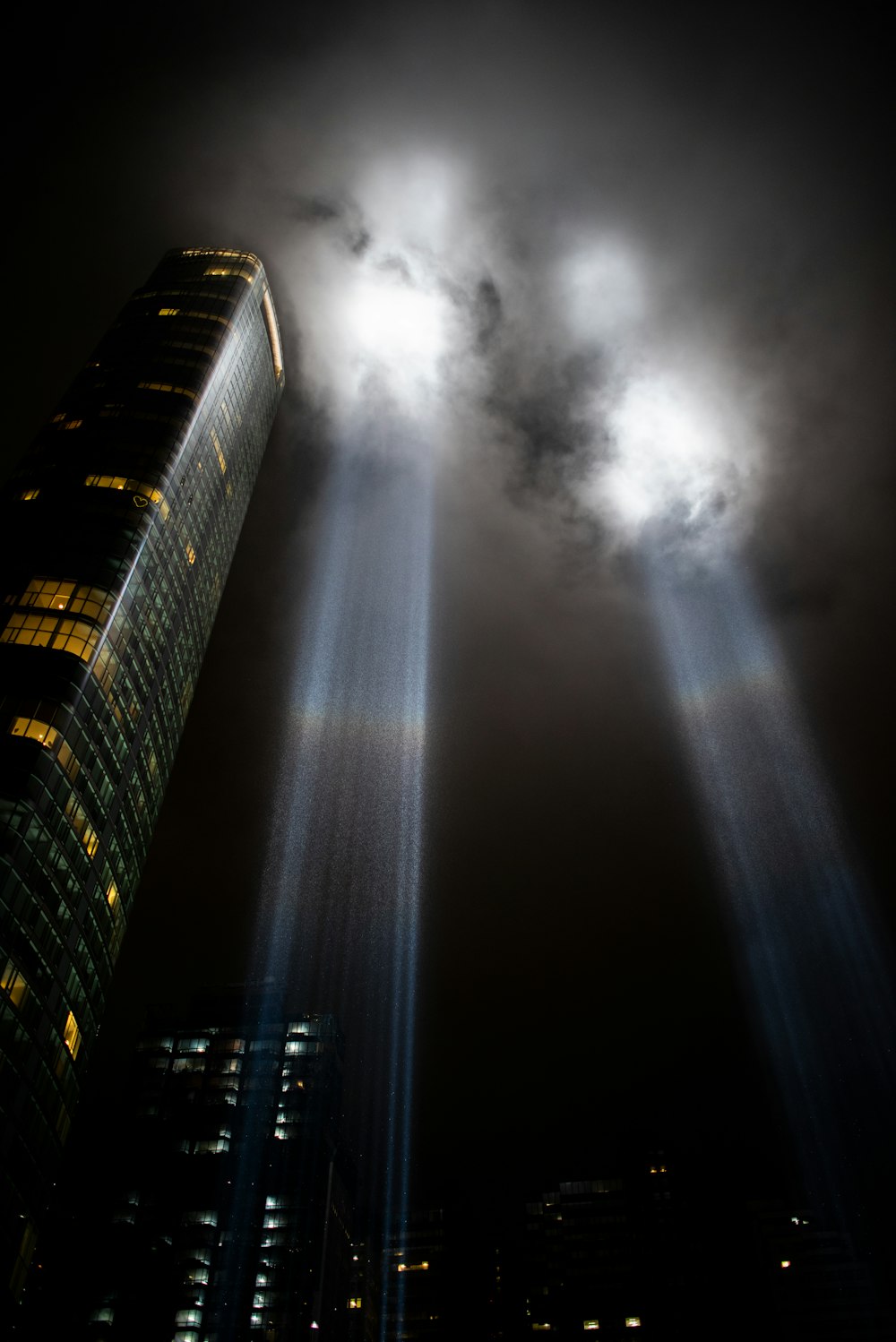 un très grand bâtiment avec deux faisceaux de lumière qui en sortent