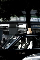 Taxi parked outside a hospital entrance with a patient getting in