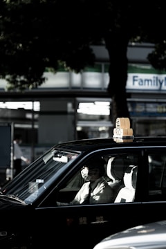 Taxi parked outside a hospital entrance with a patient getting in