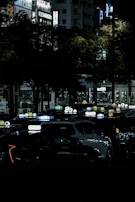 Nighttime cityscape with multiple Uber cars glowing under streetlights, each sporting Vairumokė advertising.