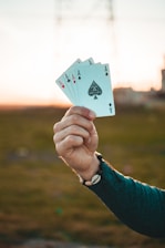 A smiling player holding a winning hand of cards with friends cheering in the background.