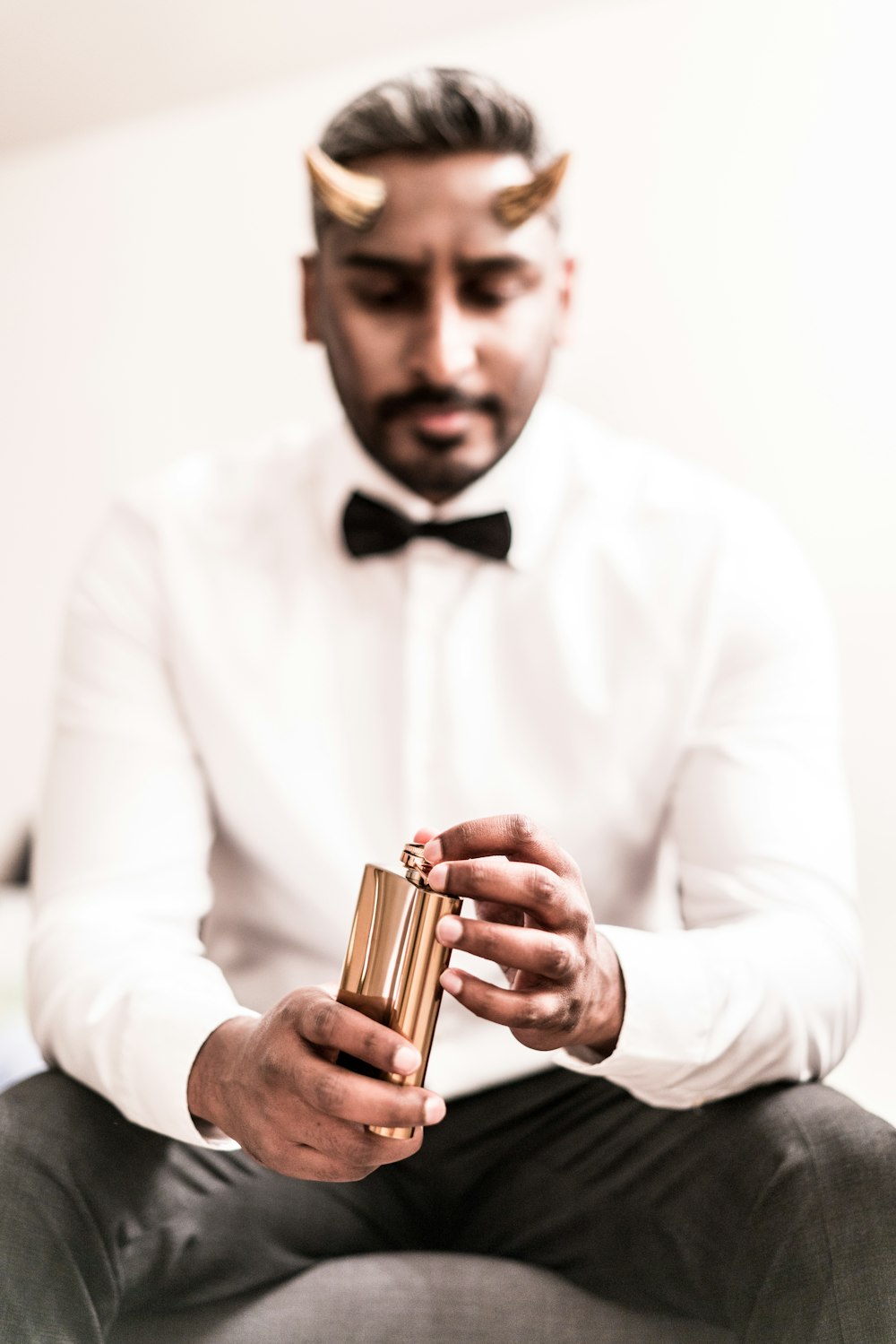 man in white dress shirt holding gold tube