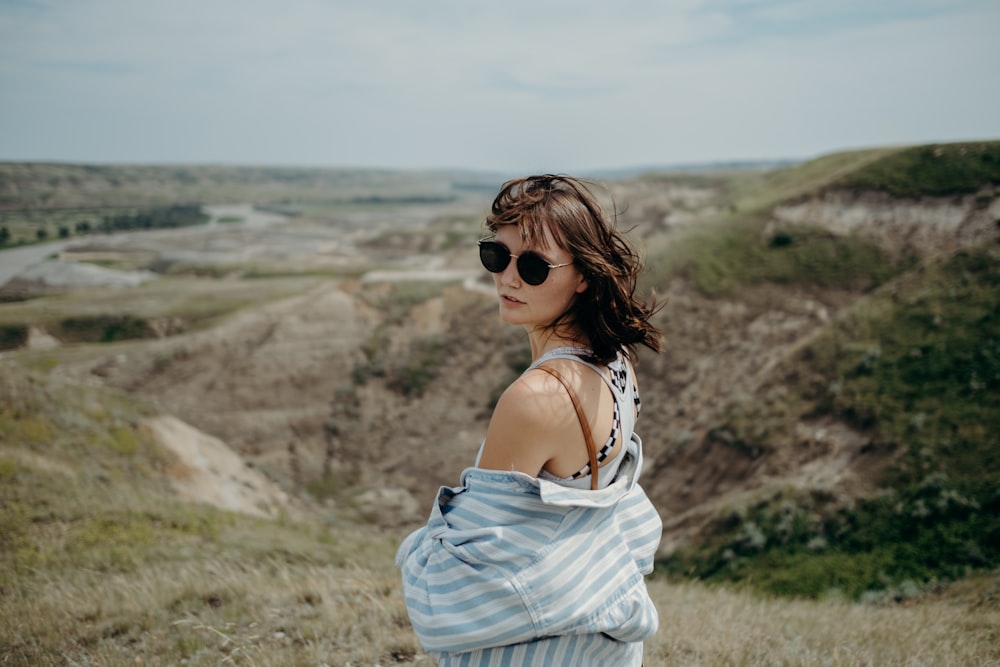 woman in white spaghetti strap dress wearing black sunglasses