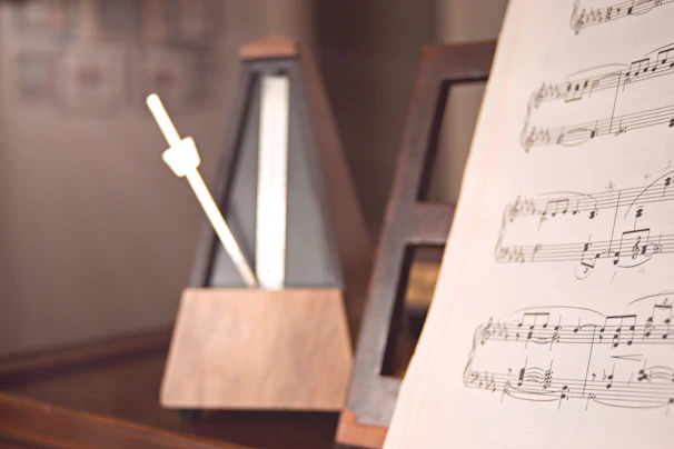 Sheet music with handwritten notes beside a classic music box on a wooden table