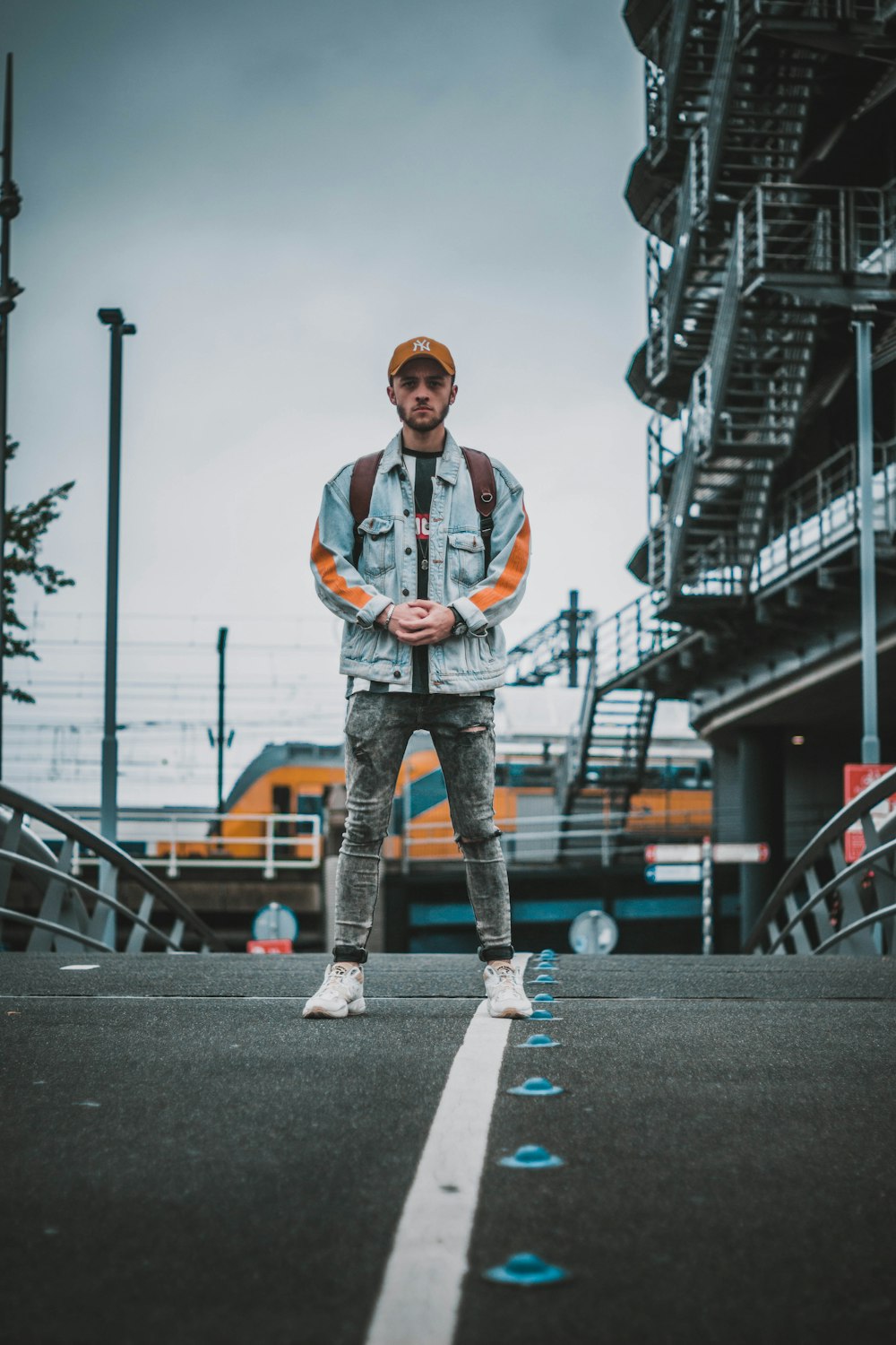 man in black and white jacket standing on gray concrete road during daytime