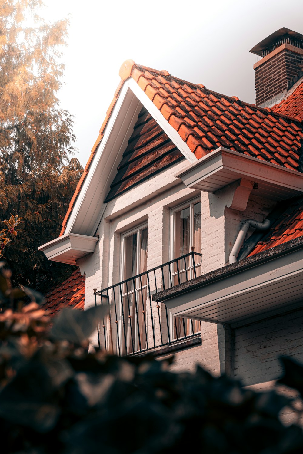 white and brown concrete house near green tree during daytime